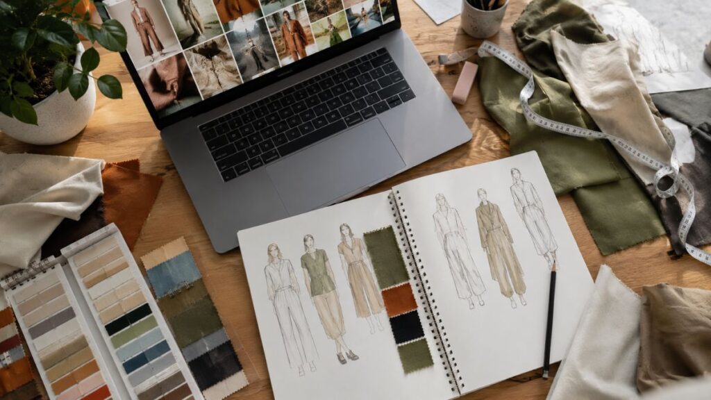 AI prompts for fashion portfolio building shown on a student's laptop and sketchbook